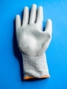 Vertical shot of an industrial work glove on a blue surface Royalty Free Stock Photo