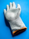 Vertical shot of an industrial work glove on a blue surface Royalty Free Stock Photo