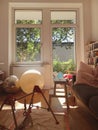 Vertical shot of the inside of a comfortable room with balls, chairs, couch, and a bookshelf