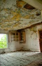 Vertical shot of an interior of an abandoned house with broken furniture and a rotten  ceiling Royalty Free Stock Photo