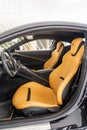 Vertical shot of an interior view of a Ferrari Roma with orange leather seats