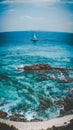 Vertical shot of an isolated sailboat in the beautiful wavy sea under the breathtaking cloudy sky Royalty Free Stock Photo