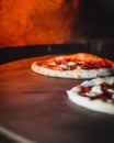 Vertical shot of an Italian pizza baking in a wood-fired oven Royalty Free Stock Photo