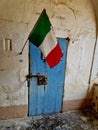 Vertical shot of Italy's flag over an old blue door Royalty Free Stock Photo