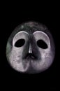 Vertical shot of a Japanese metal medieval mask on a black isolated background