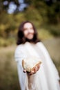 Vertical shot of Jesus Christ handing out bread with a blurred background Royalty Free Stock Photo