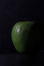Vertical shot of a juicy apple with waterdrops isolated on a black background Royalty Free Stock Photo