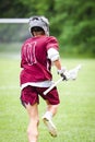 Vertical shot of a lacrosse player running in a sports field