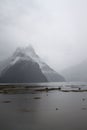 Vertical shot of the lake and mountains covered in clouds. Milford Sound, New Zealand. Royalty Free Stock Photo