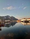 Vertical shot of a lake surrounded by buildings in Henningsvaer, Norway
