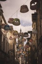 Vertical shot of lamp shades hanging in a street in Laon, France against Laon cathedral