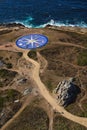 Vertical shot of a large blue compass built on the shore in front of the ocean in La Coruna, Spain