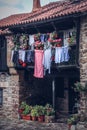 Vertical shot of laundry hanging from a balcony of a brick house