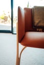 Vertical shot of a leather chair with a throw blanket draped on the back - interior inspiration