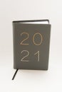 Vertical shot of a leather journal with 2021 writing on the cover on a white background