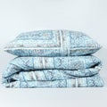 Vertical shot of a light blue patterned pillow and linens isolated on a white background Royalty Free Stock Photo