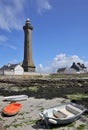 Vertical shot of the lighthouse of Eckmuhl with small boats at the coast of a sea, Penmarch, France Royalty Free Stock Photo