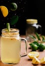 Vertical shot of lime slices falling into a glass with lemonade Royalty Free Stock Photo