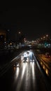 A line of cars are illuminated in the darkness of night at the Queen Mary Street in Montreal