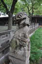 Vertical shot of a lion statue with a silly weird face in a park