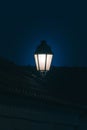 Vertical shot of a lit street lamp Royalty Free Stock Photo