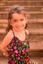 Vertical shot of a little Spanish kid with a cute face posing for a picture in a park