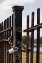 Vertical shot of a lock on old spiked fence with blurred water in the background