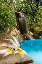 Vertical shot of a Long exposure of a poolside waterfall Royalty Free Stock Photo