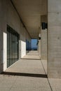 Vertical shot of a long outdoor corridor of a white stone building