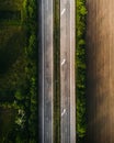Vertical shot of long roads through the fields and forests