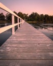 Vertical shot of a long wooden jetty at sunset. Royalty Free Stock Photo