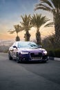 Vertical shot of a luxury and beautiful purple Audi A6 car driving on the highway