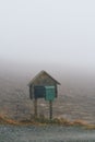 Vertical shot of a mailbox stand on a foggy day in rural Toten, Norway