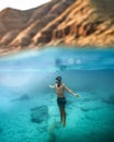 Vertical shot of a male diving in the turquoise sea