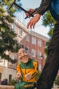 Vertical shot of a male holding an old smiling puppet in tracksuit running down the Street