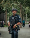 Vertical shot of a male security agent with guns and equipment in the streets of New York