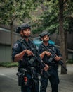 Vertical shot of male security agents with large guns and equipment in the streets of New York