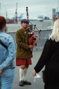 Vertical shot of a male street musician in a traditional outfit with bagpipes in Hamburg, Germany