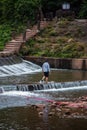 Vertical shot of a male walking near the river in Liujiang, Meishan, Sichuan, China