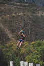 Vertical shot of a male ziplining over forest