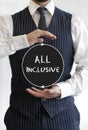 Vertical shot of a man with an all-inclusive text written on a circle in the middle of his hands