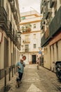 Vertical shot of a man with a dog walking in a street in Sevilla, Spain