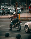 Vertical shot of a man on a motorcycle at a red traffic light at Piata Unirii (Unity square) Royalty Free Stock Photo