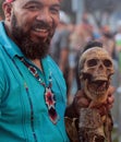 Vertical shot of a man with a skull in his hand during the Day of the Dead celebration in Florida