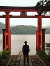 Vertical shot of a man standing in front of the lake Lake Ashi in Japan Royalty Free Stock Photo