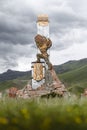 Vertical shot of man statue holding big rock on back in Kojomkul