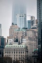 Vertical shot of Manhattan skyscrapers on a foggy day