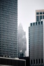 Vertical shot of Manhattan skyscrapers on a foggy day