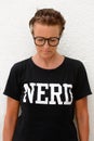 Vertical shot of mature nerd woman looking down while standing against white background outdoors Royalty Free Stock Photo