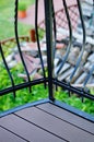 Vertical shot of the metal fence of a balcony with the view of the backyard in the background